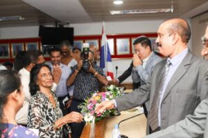 A guest being presented with a bouquet of flowers at a Society event