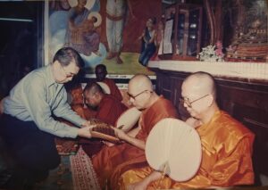 Archive photograph of an offering being presented to Buddhist monks