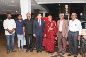 Members with a Buddhist monk and Thai representatives at a ceremony